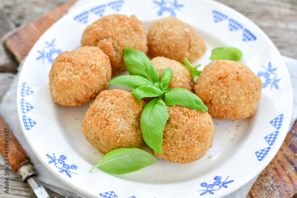 Italian arancini Cacio e pepe. Home-made rice balls with mozzarella cheese, parsley, lemon, and parmesan cheese.