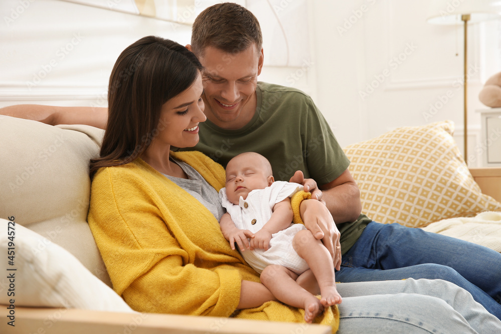 Happy couple holding their sleeping baby at home Happy couple holding their sleeping baby at home