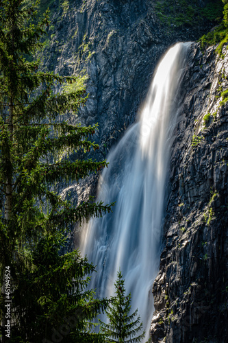 Motion blur of water rushing over rocks at waterfall in the Alps