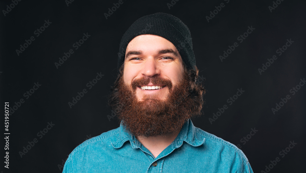 Close up portrait of a smiling bearded man over black background. Close up portrait of a smiling bearded man over black background.