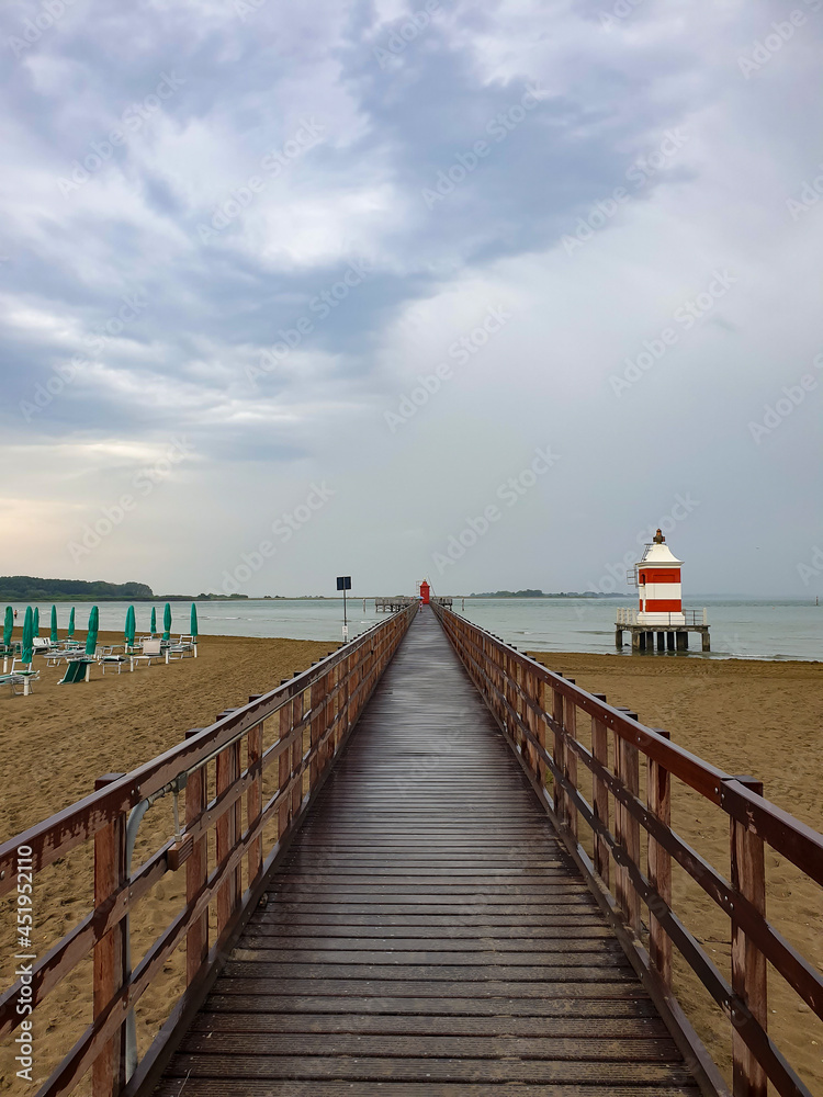 Red lighthouse at the end of a wooden pier. Red lighthouse at the end of a wooden pier.