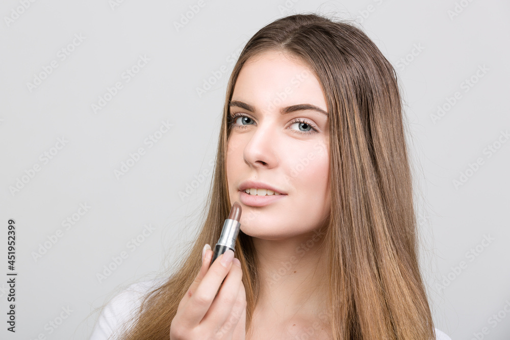 teenager woman is applying lipstick for every day make up teenager woman is applying lipstick for every day make up