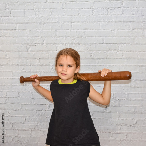 Photographie the child a girl with a baseball bat plays a bully