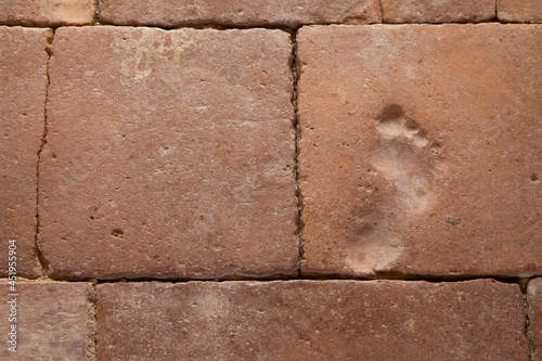 EMPREINTE DE PIED D'ENFANT SUR ANCIENNE DALLE EN TERRE CUITE photo