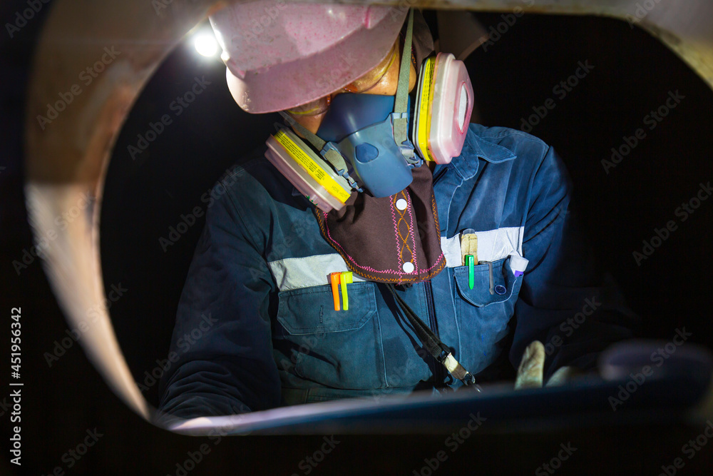 Worker male mask into the tank oil area inspection record tank confined space Worker male mask into the tank oil area inspection record tank confined space