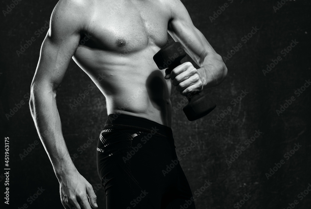 Naklejka premium man with a pumped-up torso muscles dumbbells exercise gym