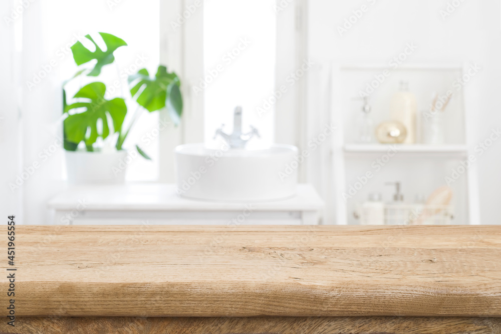 Empty wooden table top with blurred bathroom sink interior background