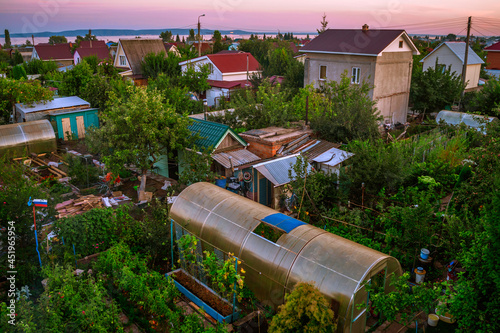 Country houses with plots for a vegetable garden. Russian summer cottages from a height at sunset.