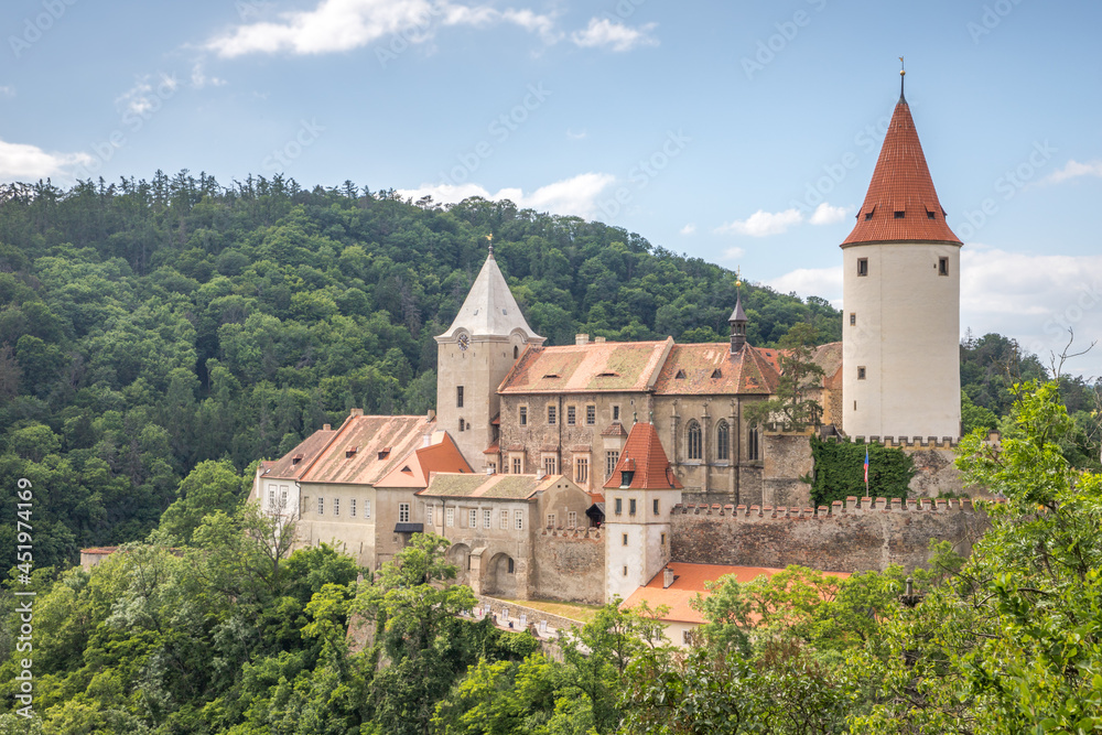 medieval castle with a round tower in the valley between the hills