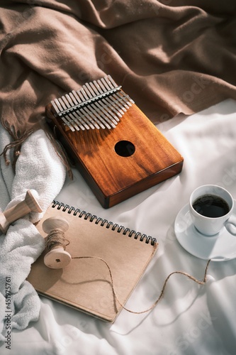 Kalimba musical African instrument. Style concept kalimba in bed with book, tea. Relax and enjoy. Vintage concept