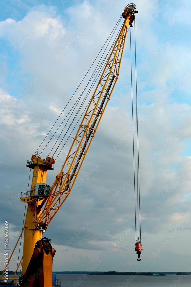yellow cranes in the cargo river port. coal for loading into the freight train. Port in Vyborg on the Gulf of Finland. vertical photo