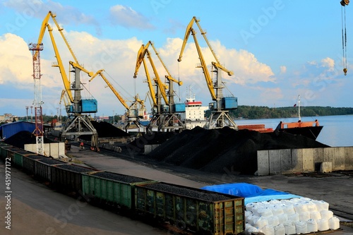 yellow cranes in the cargo river port. coal for loading into the freight train. Port in Vyborg on the Gulf of Finland photo