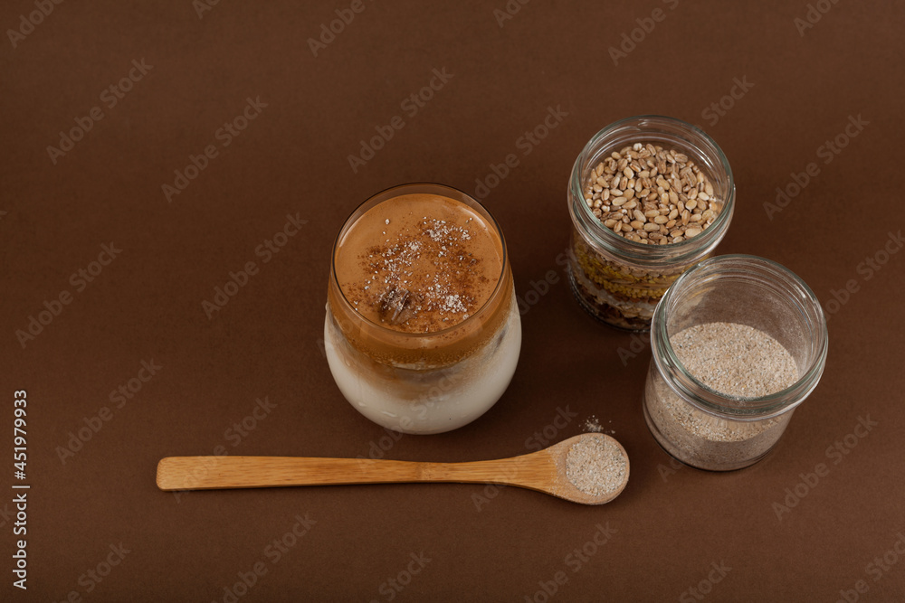 Dalgona Misugaru Latte and ingredients on brown background. Korean refreshing beverage made from roasted multi grain powder, milk and coffee. Popular breakfast drink Dalgona Misugaru Latte and ingredients on brown background. Korean refreshing beverage made from roasted multi grain powder, milk and coffee. Popular breakfast drink