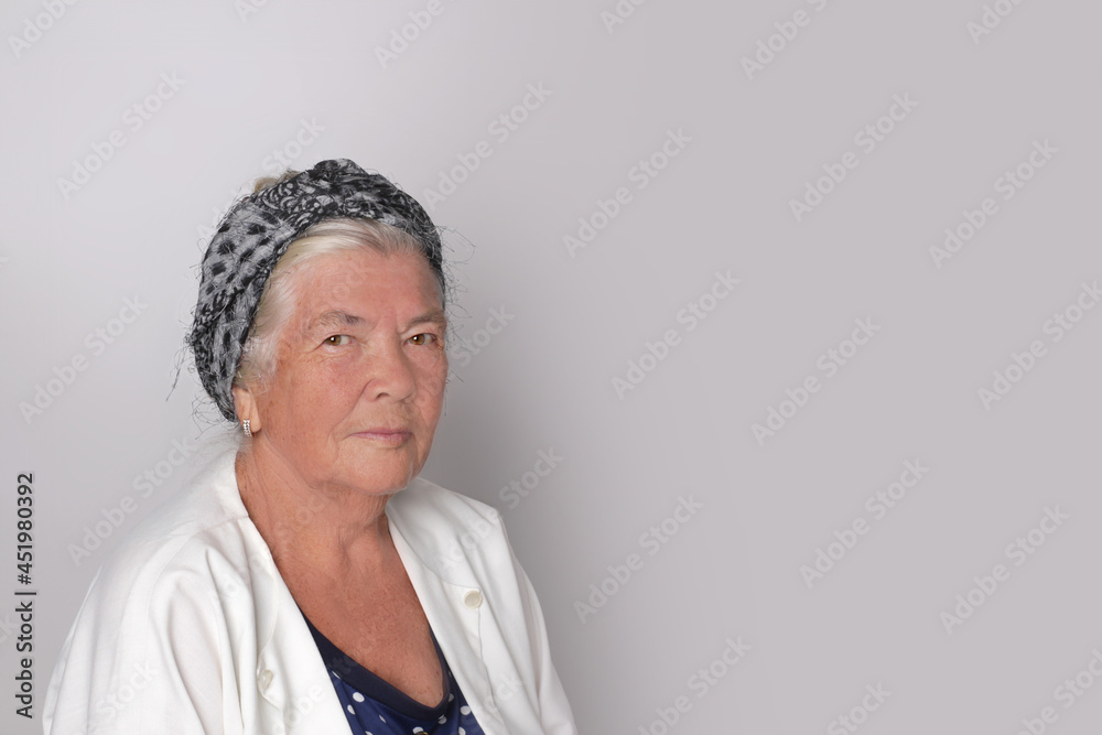Portrait of attractive cute adult gray-haired woman against gray background with copy space. Portrait of attractive cute adult gray-haired woman against gray background with copy space.