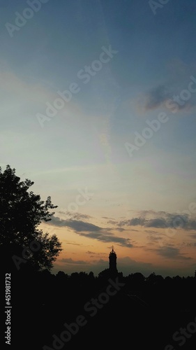 Sunset bright orange gold sky with white clouds under the church. Nature background