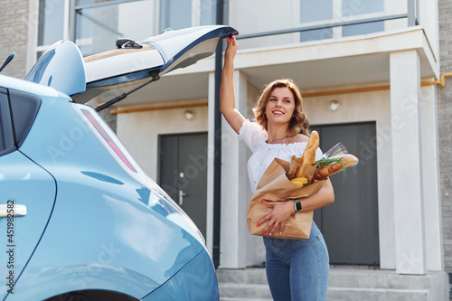 After shopping. Young woman in casual clothes with her electromobile outdoors at daytime photo