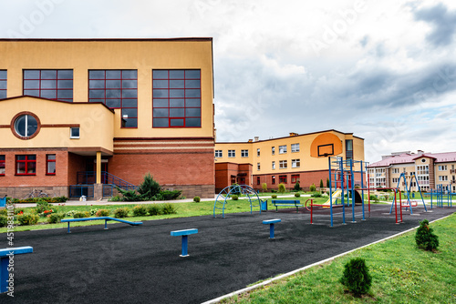 Exterior view of modern public school building with playground. photo