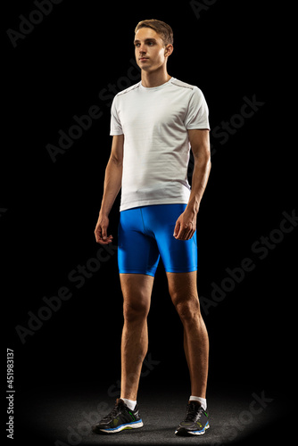 Portrait of Caucasian professional male athlete in sports uniform isolated on dark studio background. Muscular, sportive man. Concept of action, motion, youth, healthy lifestyle.