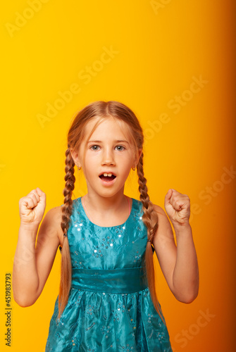 Blimey. A studio shot of an emotionally adorable little European girl raising her eyebrows and covering her open mouth with her hand  surprised and shocked  showing her true astonished reaction to une