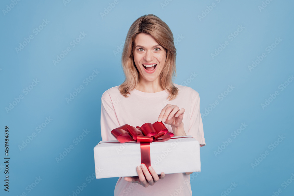 Portrait of excited amazed shocked lady hold gift box open mouth omg reaction on blue background Portrait of excited amazed shocked lady hold gift box open mouth omg reaction on blue background