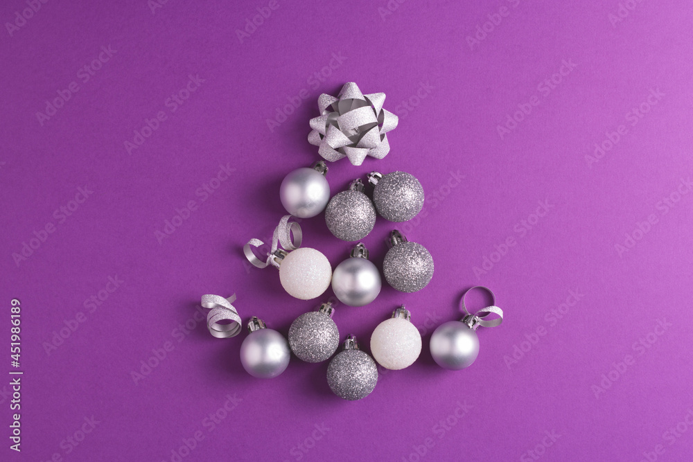 Christmas tree made of metallic baubles on purple background. Top view. Christmas and New Year concept. Christmas tree made of metallic baubles on purple background. Top view. Christmas and New Year concept.
