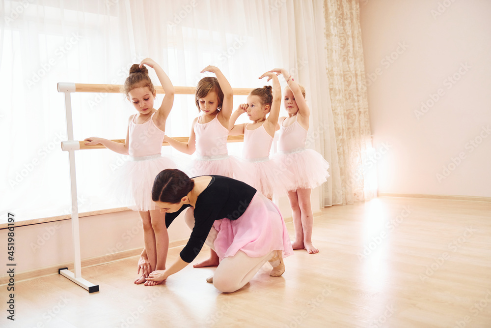 Working with coach. Little ballerinas preparing for performance by practicing dance moves Working with coach. Little ballerinas preparing for performance by practicing dance moves