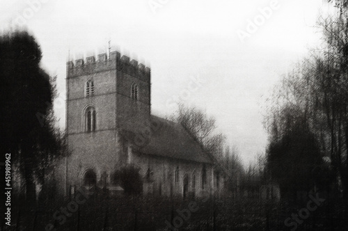An atmospheric church in the English countryside. On a moody winters day. With a grunge, textured edit.