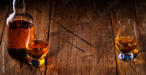 Scotch Whiskey in special glasses and bottle, old wooden background with negative space photo