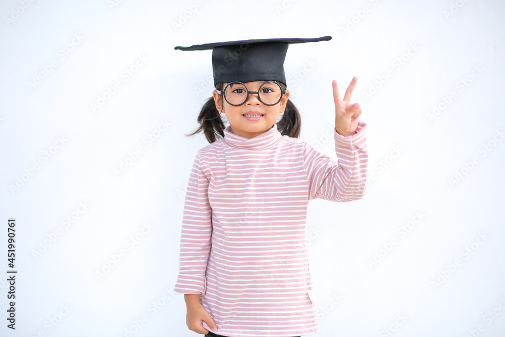 A little girl asia looks happy while celebrating his graduation and holding a diploma and graduation cap which increases the development and enhances outside the classroom learning skills concept. A little girl asia looks happy while celebrating his graduation and holding a diploma and graduation cap which increases the development and enhances outside the classroom learning skills concept.