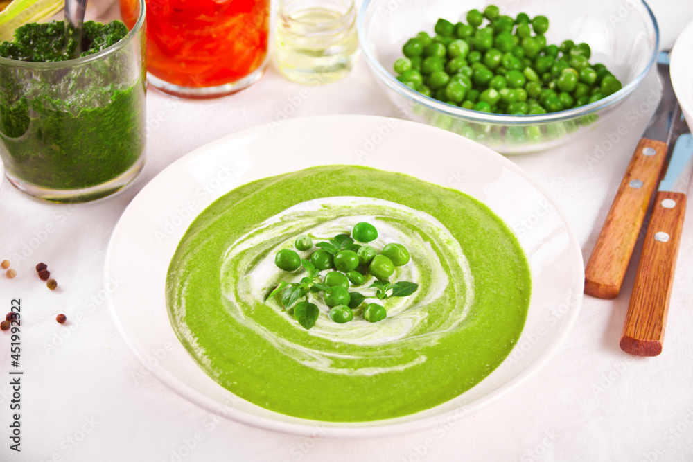 Delicious vegetable soup with potato, broccoli, green pea and spinach on the dinner table Delicious vegetable soup with potato, broccoli, green pea and spinach on the dinner table