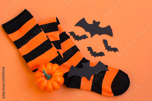 Orange - and-black striped socks on an orange background. Halloween photo