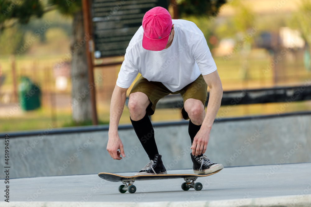 Fototapeta premium young skateboarder doing a trick at a skateboard park