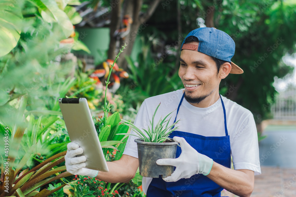 Happy man garden shop owner use tablet sale online small floral on internet shop Happy man garden shop owner use tablet sale online small floral on internet shop