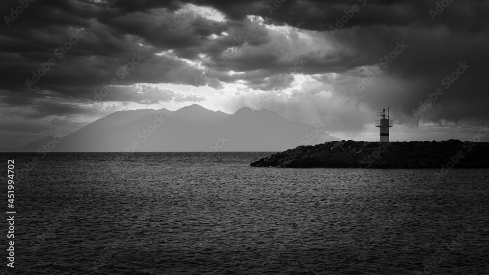 black and white lighthouse and beach on a cloudy and rainy day