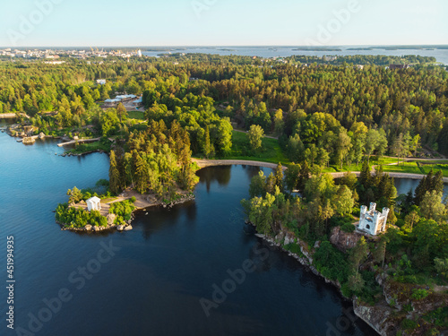 Aerial view of Monrepos park in Vyborg city. Summer, green forest, island, castle, blue clear sky 