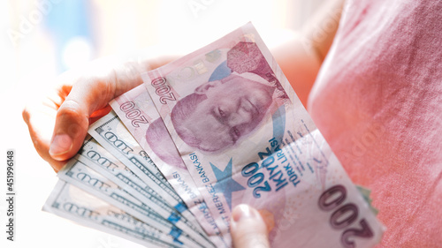 The girl's Hands holding Turkish Lira and American Dollar. Concept of the money exchange photo