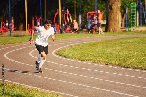 Man in sportive unifrom running on the track at daytime © standret