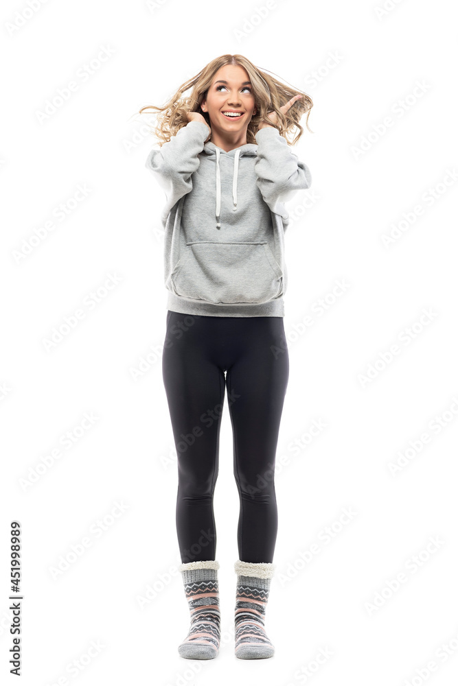 Happy playful woman in home wear messing up and playing with tousled hair style. Full body portrait isolated on white background Happy playful woman in home wear messing up and playing with tousled hair style. Full body portrait isolated on white background