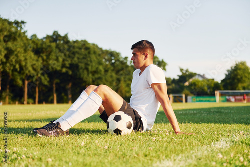 Takes a break. Young soccer player have training on the sportive field