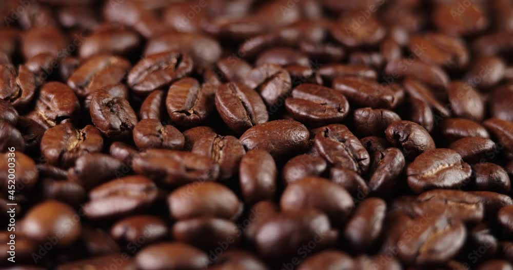 Roasted coffee bean. Fragrant coffee beans scrolls slowly around the camera. Slow Motion Close Up of Whole Roasted Coffee Beans. Roasted coffee bean. Fragrant coffee beans scrolls slowly around the camera. Slow Motion Close Up of Whole Roasted Coffee Beans.