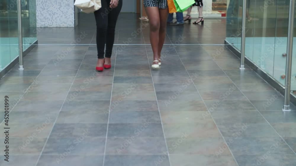 Close-up of young African girls walking in a shopping center with shopping and chatting Close-up of young African girls walking in a shopping center with shopping and chatting