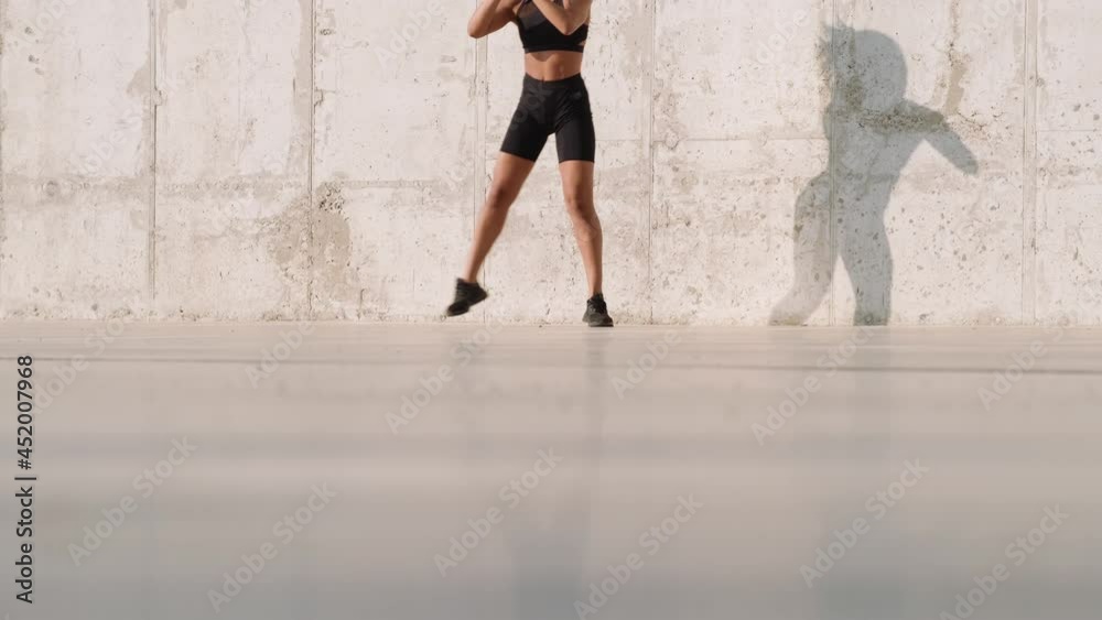 A cropped view of a focused african american woman jumping while training outside A cropped view of a focused african american woman jumping while training outside