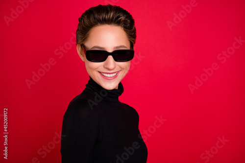 Photo of young cheerful charming woman wear smile wear black sunglass isolated on red color background