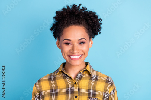 Photo portrait curly woman wearing checkered shirt smiling happy cheerful isolated pastel blue color background