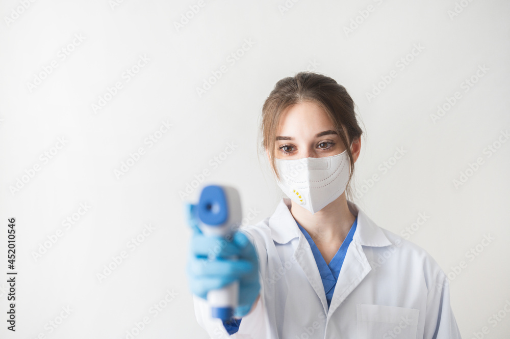 Selective focus hand of doctor in PPE using infrared thermometer gun to check temperature for coronavirus symptoms. Initial screening for covid19. Coronavirus and covid19 concept. Selective focus hand of doctor in PPE using infrared thermometer gun to check temperature for coronavirus symptoms. Initial screening for covid19. Coronavirus and covid19 concept.