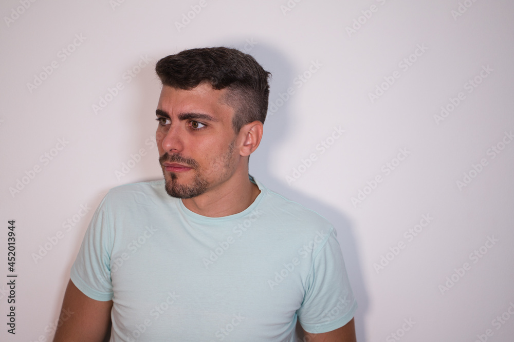 young man on white background looking in profile and smiling. Concept happiness and expressions. young man on white background looking in profile and smiling. Concept happiness and expressions.