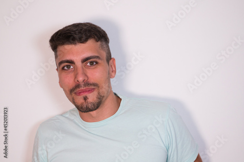 young man on white background looking in profile and smiling. Concept happiness and expressions.