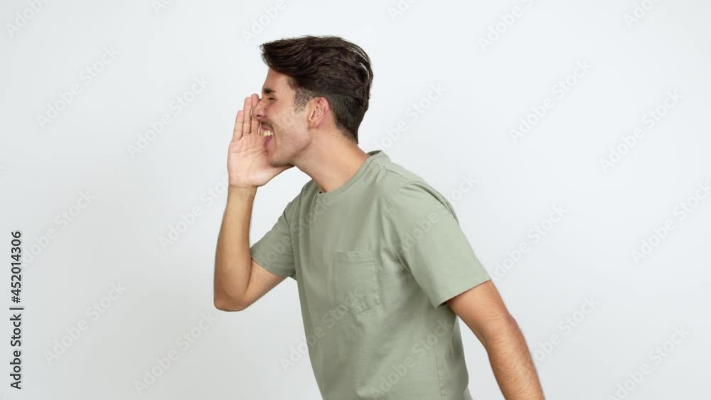 Young man shouting to the lateral and announcing something over isolated background Young man shouting to the lateral and announcing something over isolated background