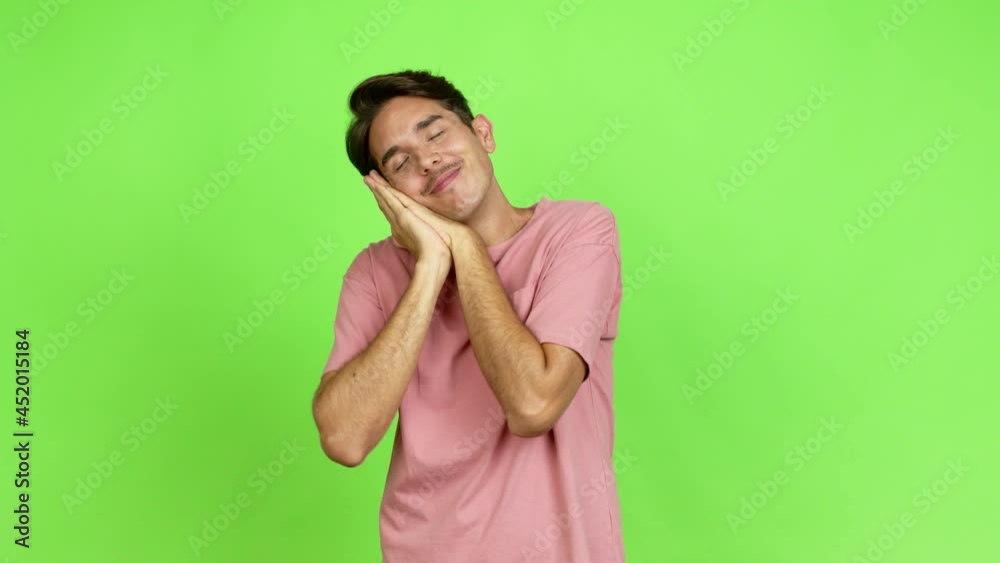 Young man making sleep gesture. Adorable and sweet expression over isolated background. Green screen chroma key Young man making sleep gesture. Adorable and sweet expression over isolated background. Green screen chroma key