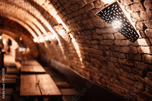 Old wine bottles dusting in an underground tratitional cellar. Small and old wine cellar with full wine bottles. Winery concept. Valtice Castle in South Moravia, Czech Republic, Europe photo